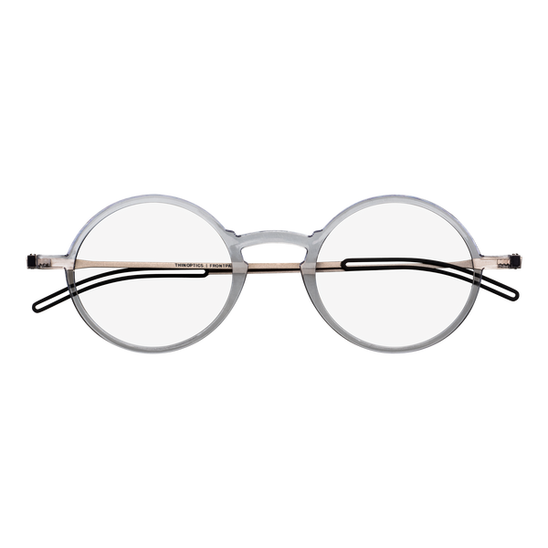 Clear round eyeglasses with a thin gold bridge rest against a grey background.