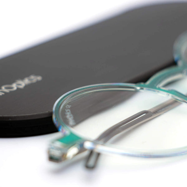 ThinOptics reading glasses and a sleek black case: minimalist design with thin and round lenses. The compact, brushed metal case offers a modern, portable solution for individuals needing reading glasses.