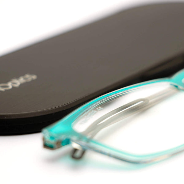 ThinOptics reading glasses and a sleek black case: minimalist design with thin lenses. The compact, brushed metal case offers a modern, portable solution for individuals needing reading glasses.