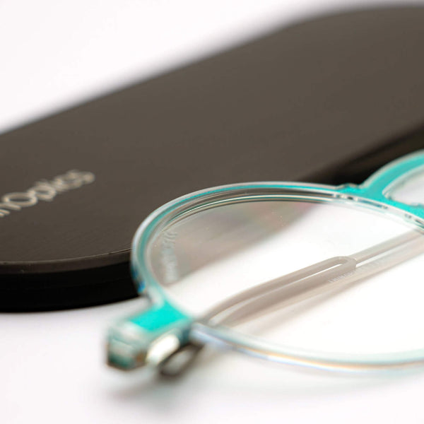 ThinOptics reading glasses and a sleek black case: minimalist design with thin and round lenses. The compact, brushed metal case offers a modern, portable solution for individuals needing reading glasses.
