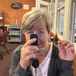 Woman holds smartphone close to her face and gestures with her other hand in a diner.