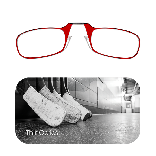 Red ThinOptics reading glasses rest above a black and white image of worn hockey sticks lined up in a locker room.