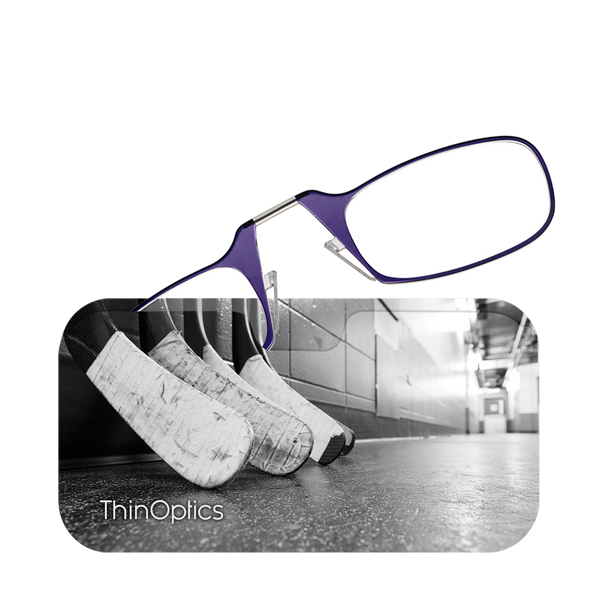 Purple ThinOptics reading glasses rest on a row of hockey sticks in a locker room.