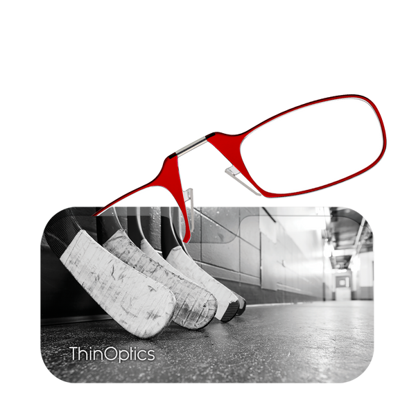 Red ThinOptics reading glasses rest on hockey sticks in a locker room.