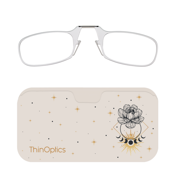 Silver ThinOptics reading glasses rest on a beige case adorned with a celestial design of a flower, moon phases, and stars.