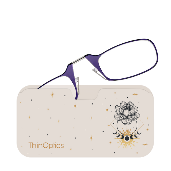 Purple ThinOptics reading glasses rest folded atop their matching beige case featuring a celestial design.