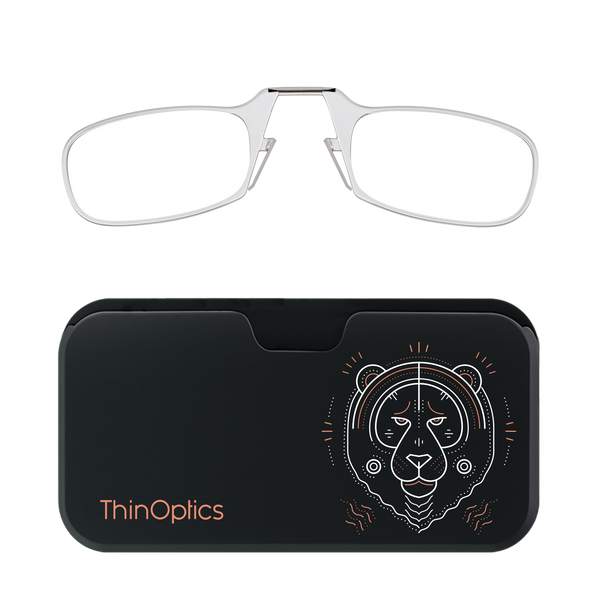 Silver ThinOptics reading glasses folded atop a black carrying case featuring a minimalist, geometric tiger design.
