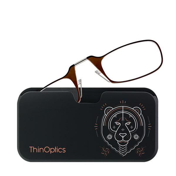 Brown ThinOptics reading glasses rest folded on their compact black case featuring a stylized geometric tiger design.