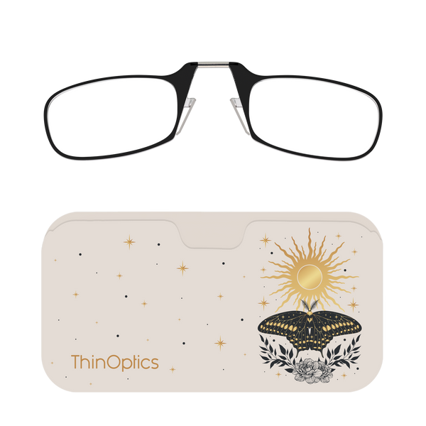 Black reading glasses folded on top of a beige case decorated with a celestial sun, butterfly, and floral design.
