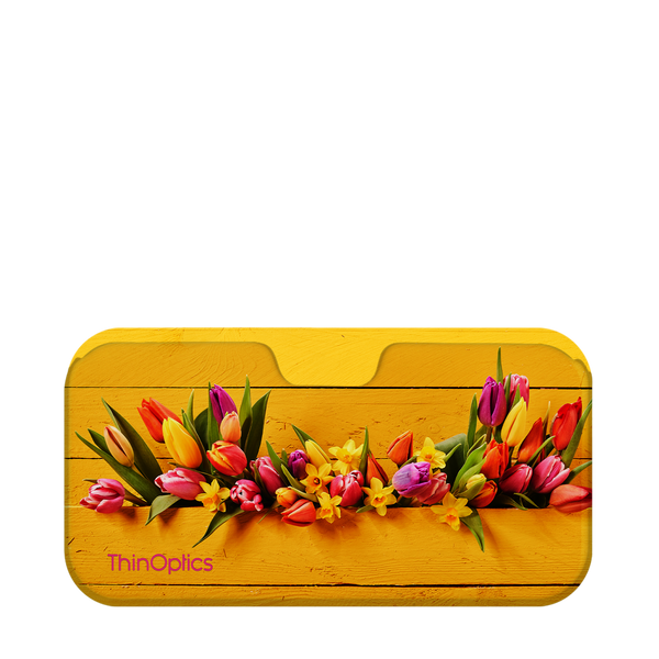 Colorful tulips and daffodils rest in a yellow wooden box.