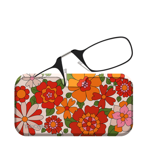 Black ThinOptics reading glasses rest unfolded on top of their floral patterned case.