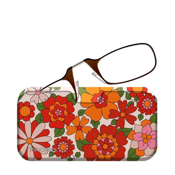 Brown ThinOptics reading glasses rest unfolded atop their floral patterned case.