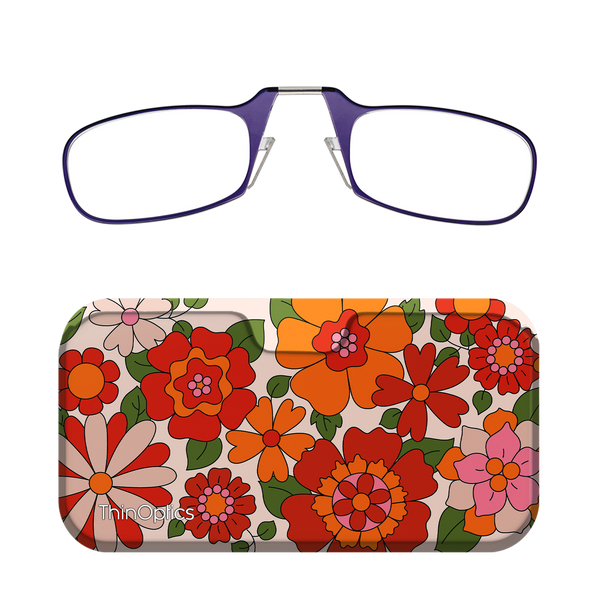 Purple reading glasses fold in the center and rest atop a floral patterned case.