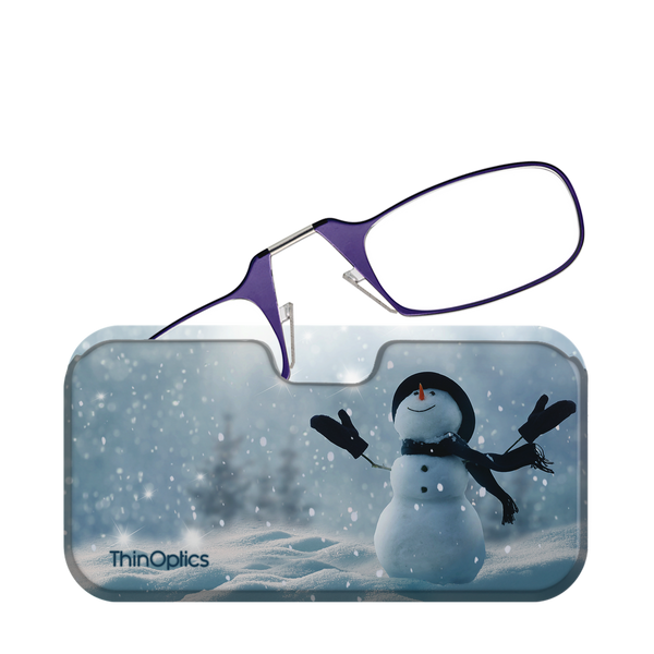 Purple ThinOptics reading glasses rest on a festive case depicting a snowy scene with a cheerful snowman.