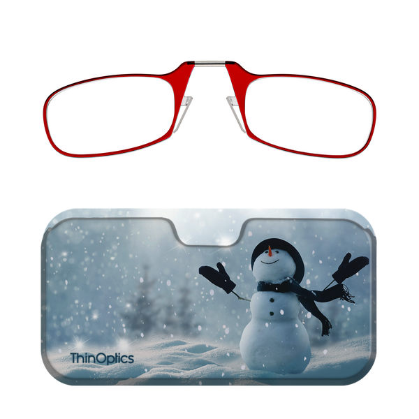 Red ThinOptics reading glasses rest atop a festive case featuring a snowman in a snowy landscape.