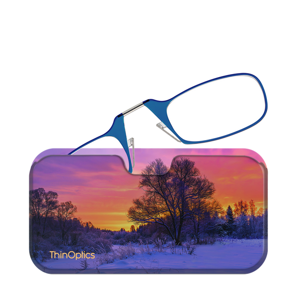 Blue ThinOptics reading glasses rest on a slim case featuring a vibrant sunset over a snow-covered landscape.