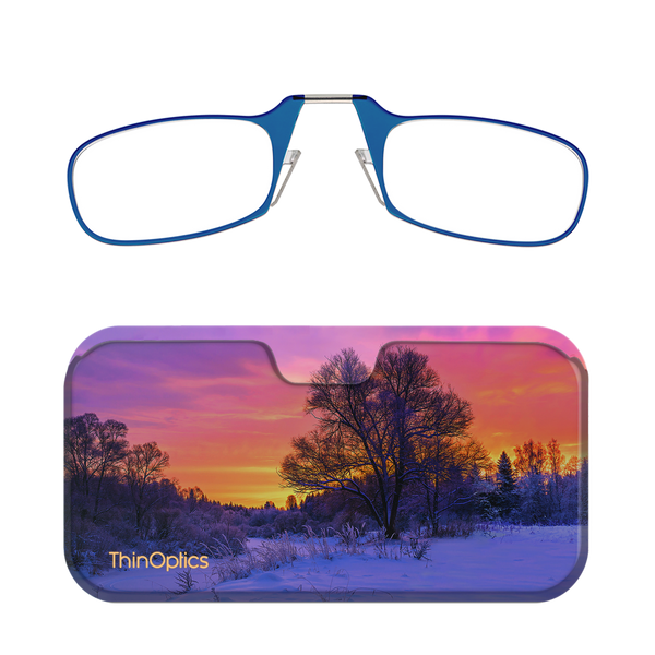 Blue ThinOptics reading glasses folded in their matching case featuring a sunset over a snowy landscape.