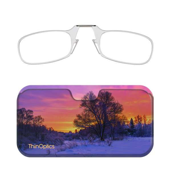 Silver ThinOptics reading glasses fold into a slim case featuring a winter sunset over a snow-covered landscape.