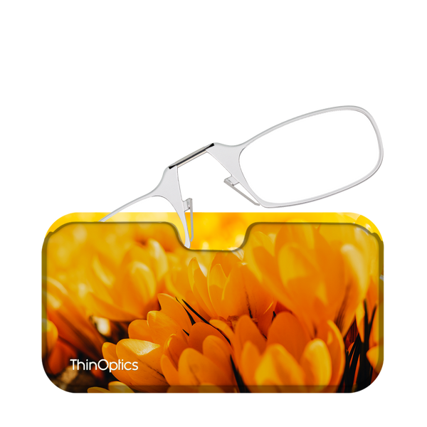 Silver ThinOptics reading glasses rest unfolded on their yellow floral case.