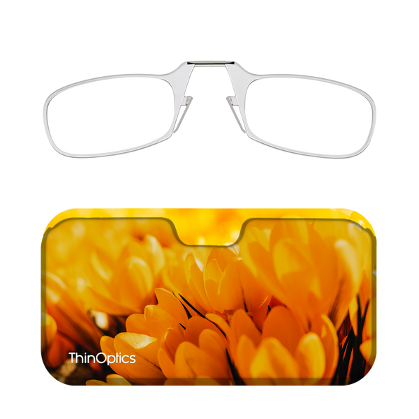 Silver ThinOptics reading glasses fold compactly into a bright yellow case featuring a close-up of crocus flowers.