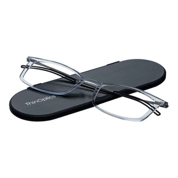 ThinOptics reading glasses and a sleek black case: minimalist design with thin lenses. The compact, brushed metal case offers a modern, portable solution for individuals needing reading glasses.