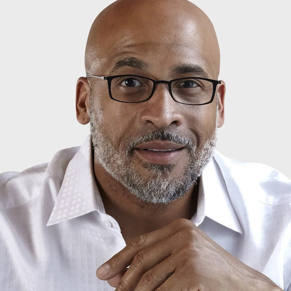 "Confident man with glasses smiles directly at the camera."