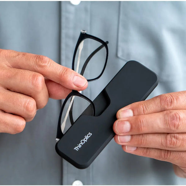 ThinOptics Black Frame Connect Reading Glasses and a sleek black Connect case: minimalist design with thin lenses. The compact, polycarbonate case offers a modern, portable solution for individuals needing reading glasses.