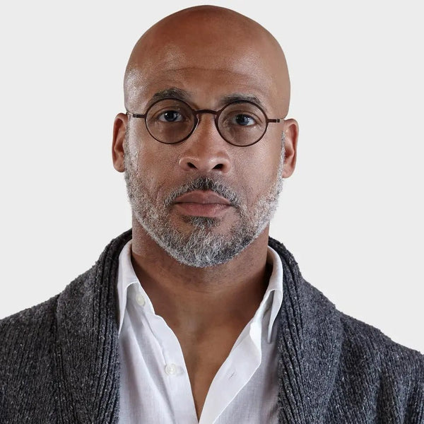 The image shows a pair of round eyeglasses and a sleek, rectangular eyeglass case. The eyeglasses have a tortoise frame with thin, round lenses and a bridge that connects the two lenses. The temples of the glasses are thin and black, with the brand name "ThinOptics" visible on the inside of the right temple. This image showcases Manhattan Full Frame Reading Glasses.