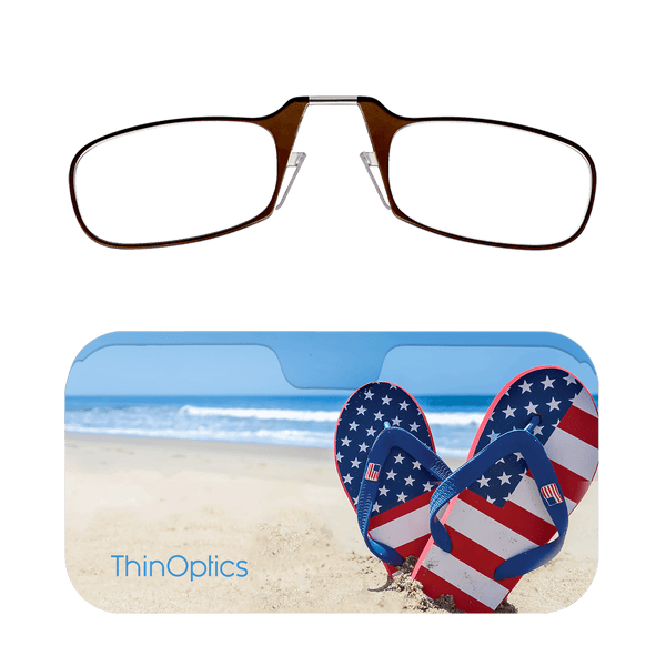 Brown ThinOptics reading glasses folded atop a blue case featuring patriotic flip-flops on a beach.