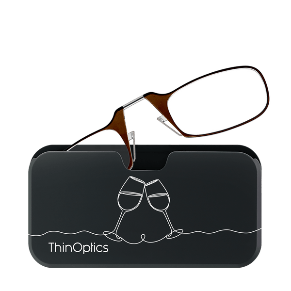 Brown ThinOptics reading glasses rest unfolded on their slim black carrying case decorated with a minimalist wine glass design.