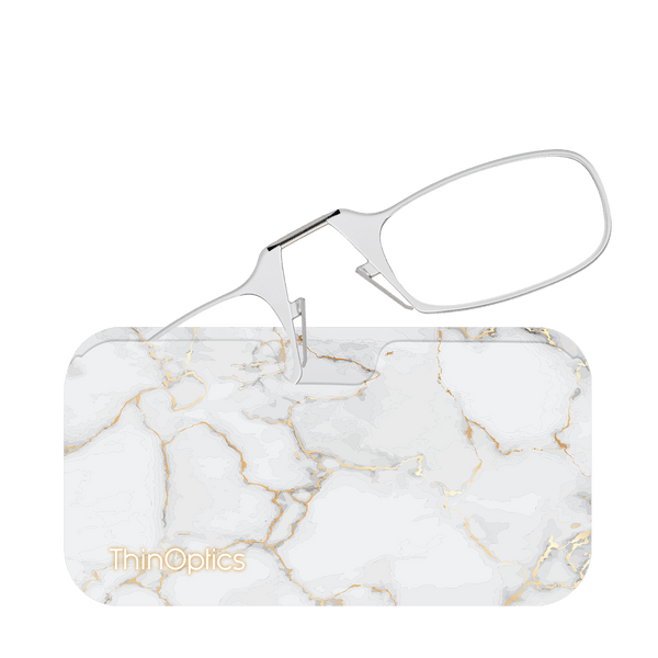 ThinOptics silver reading glasses rest unfolded on their white-and-gold marble case.