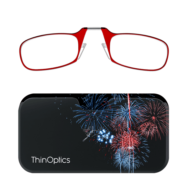 Red ThinOptics reading glasses folded atop a black case featuring a colorful fireworks display.