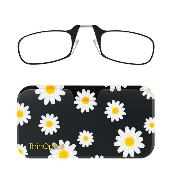 A pair of ThinOptics reading glasses with a black frame rests atop a black daisy-patterned compact case.