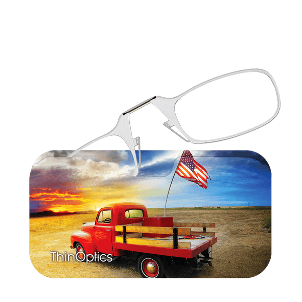 ThinOptics reading glasses folded on a case displaying a vintage red truck, American flag, and a golden sunset.