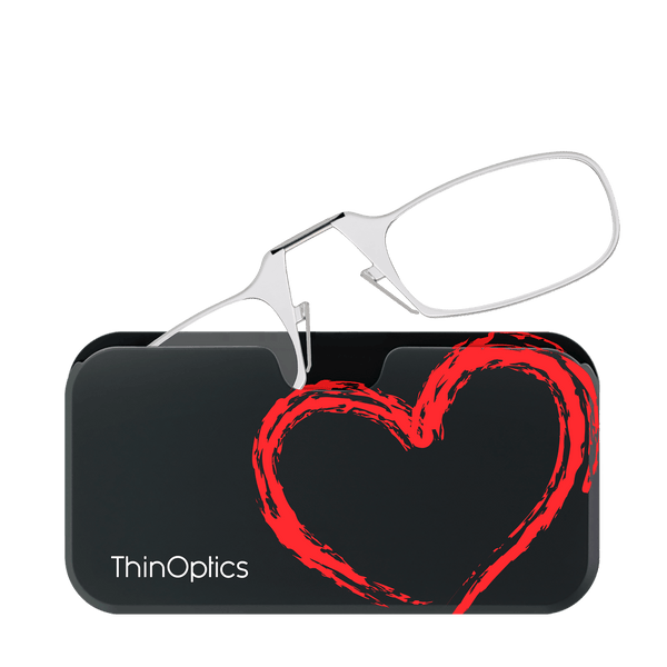 ThinOptics reading glasses rest on a black case featuring a bold, red heart design.