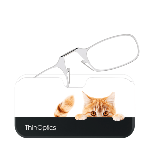 Silver ThinOptics reading glasses rest on a smartphone. A playful ginger cat peeks over the top of the phone.