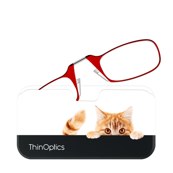 A playful ginger cat peeks over a smartphone, with stylish red ThinOptics reading glasses perched on top, ready for easy access.