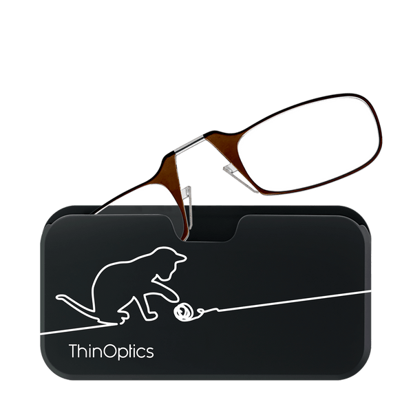 Brown ThinOptics reading glasses rest folded on their compact black case, featuring a playful cat silhouette batting at a string.