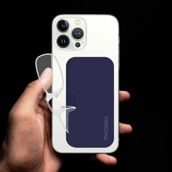 Hand holds a smartphone with ThinOptics readers conveniently attached to the back.