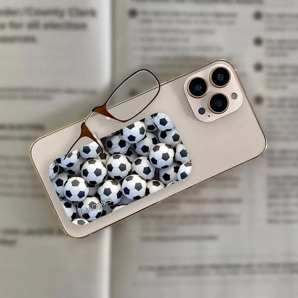 ThinOptics reading glasses with a soccer ball pattern case rest on a smartphone.
