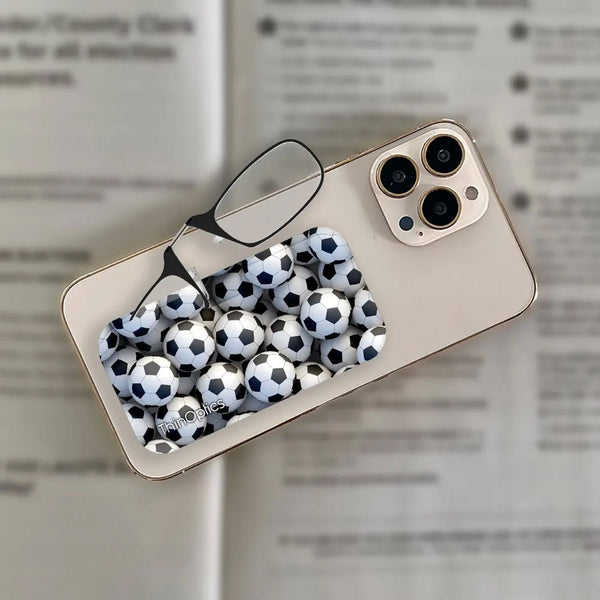 ThinOptics reading glasses with soccer ball case attached to a smartphone.