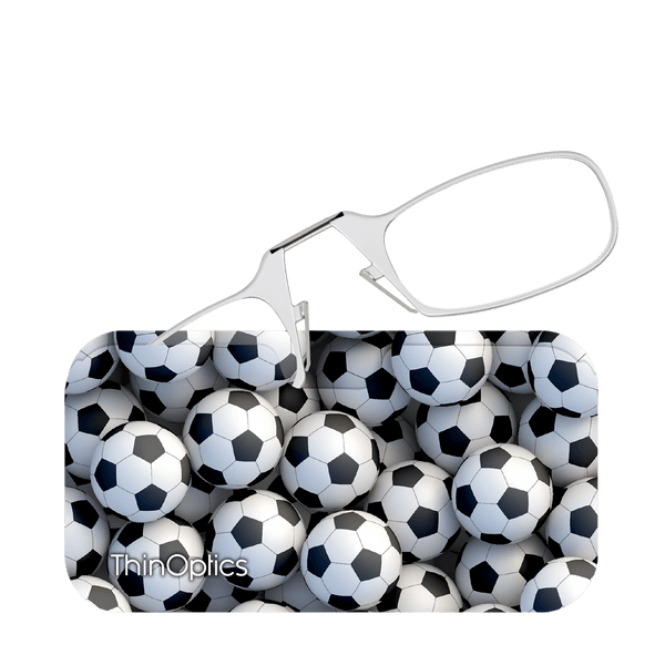 Silver ThinOptics reading glasses rest on a case featuring a close-up pattern of classic black and white soccer balls.