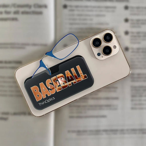 A pair of ThinOptics blue reading glasses rest on a baseball-themed phone case, showcasing the product's slim design and convenient portability.