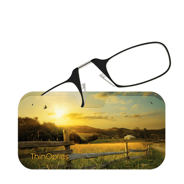 ThinOptics reading glasses rest on a scenic landscape card featuring a golden sunset over a farm field.