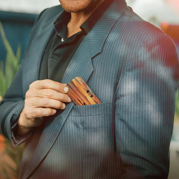 This image displays a pair of black-rimmed Readers alongside a glasses case. The glasses case features a scenic photograph depicting a person walking a dog along a beach during a vibrant sunset. The sky is filled with warm hues of orange, yellow, and pink, which reflect off the water, creating a serene and picturesque atmosphere. The silhouettes of the person and the dog add a sense of tranquility and companionship to the image.
