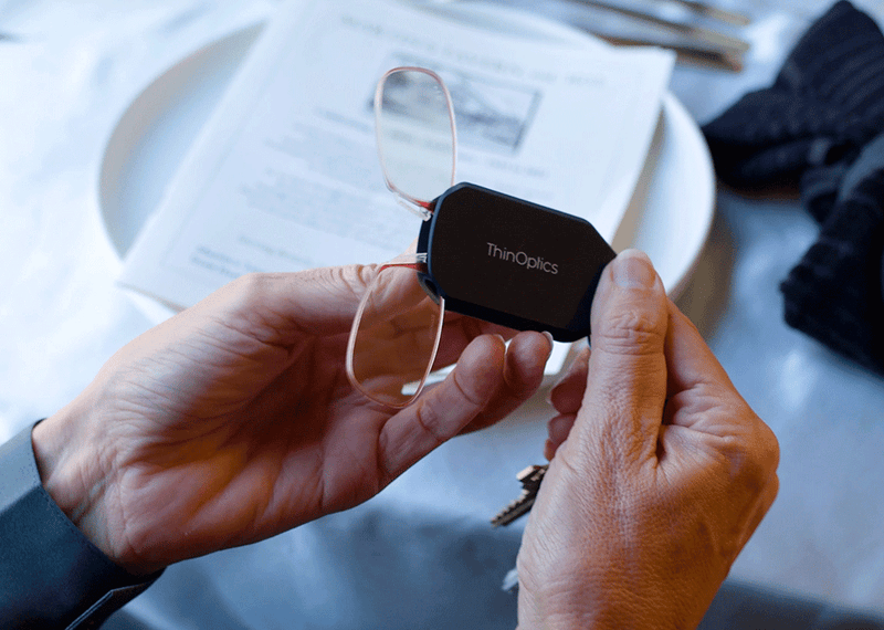 Woman holding Keychain Case and a pair of Readers