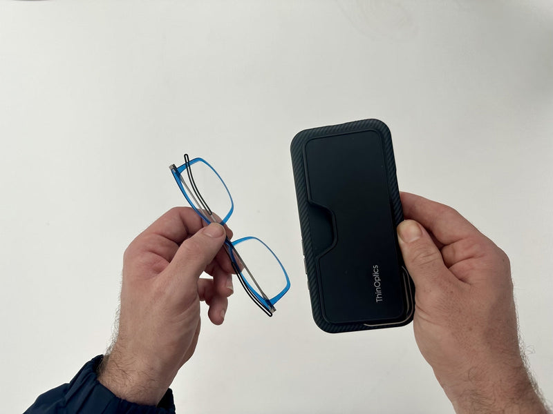 A pair of hands holding a phone with an attached MagSafe Connect Case and Brooklyn full frame rectangular Reading Glasses.