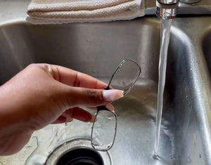 ThinOptics Readers being cleaned with running sink water.