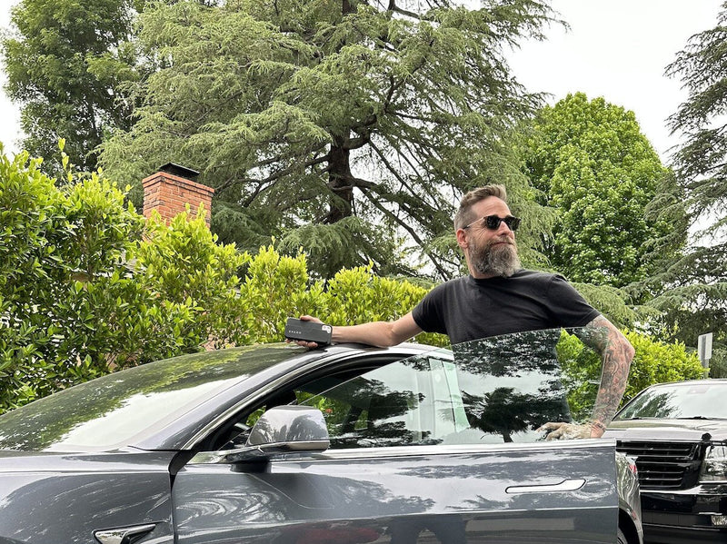 Man standing at his car wearing ThinOptics Sunglasses