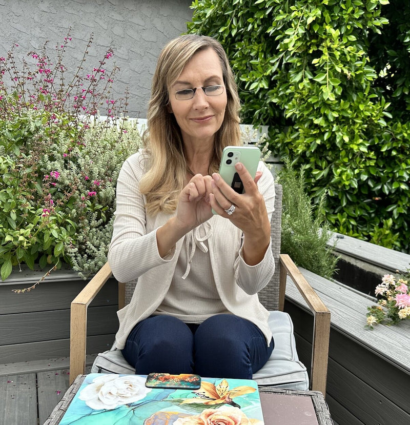 Woman wearing ThinOptics Readers and reading on her phone outdoors.